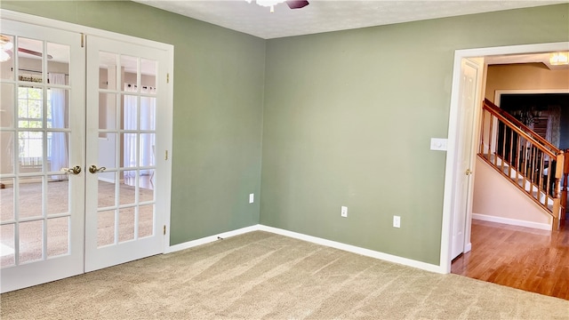 empty room with a textured ceiling, ceiling fan, french doors, and carpet flooring