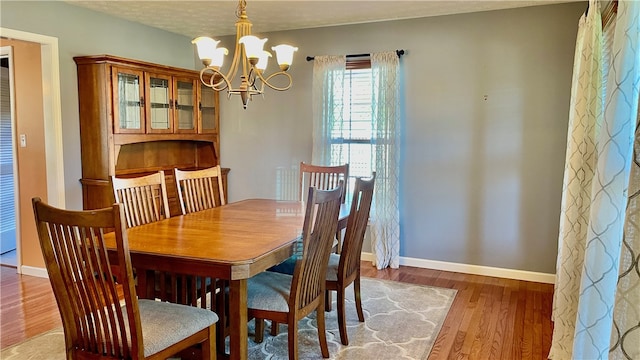 dining room featuring hardwood / wood-style floors, an inviting chandelier, and a textured ceiling