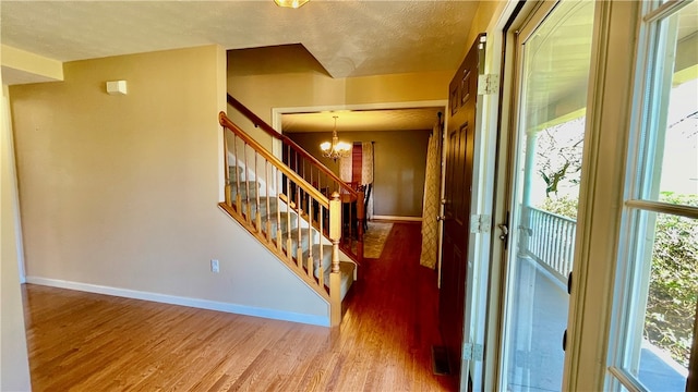 entrance foyer featuring a chandelier, wood-type flooring, and a textured ceiling