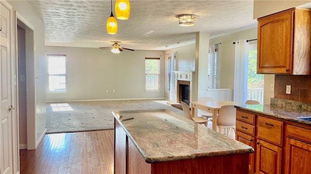 kitchen featuring plenty of natural light, decorative light fixtures, and light hardwood / wood-style floors