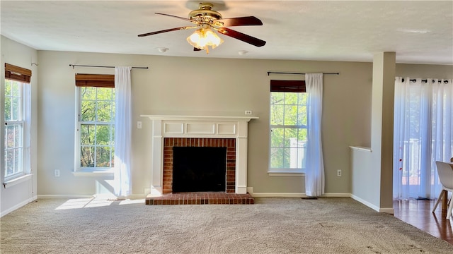 unfurnished living room with a brick fireplace, plenty of natural light, and light carpet