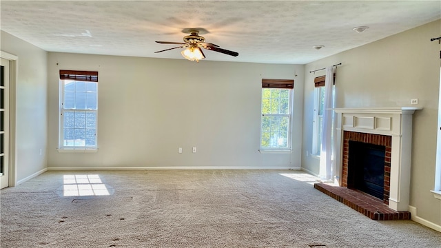 unfurnished living room featuring light colored carpet, a fireplace, ceiling fan, and a textured ceiling