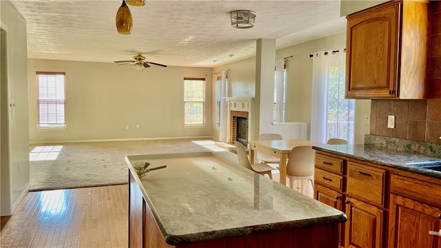 kitchen with a kitchen island, a wealth of natural light, and light hardwood / wood-style floors