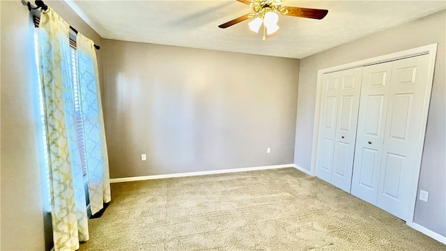 unfurnished bedroom featuring a closet, carpet flooring, and ceiling fan