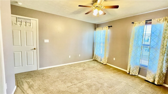 spare room with light colored carpet and ceiling fan