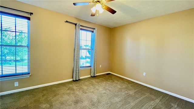 carpeted spare room with a healthy amount of sunlight and ceiling fan