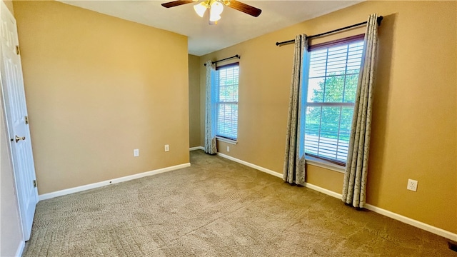 unfurnished room with ceiling fan and light carpet