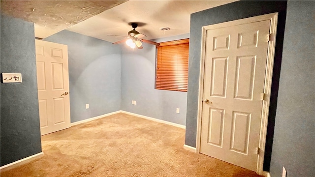 carpeted spare room with ceiling fan