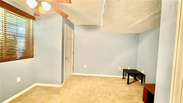 interior space with ceiling fan and a textured ceiling