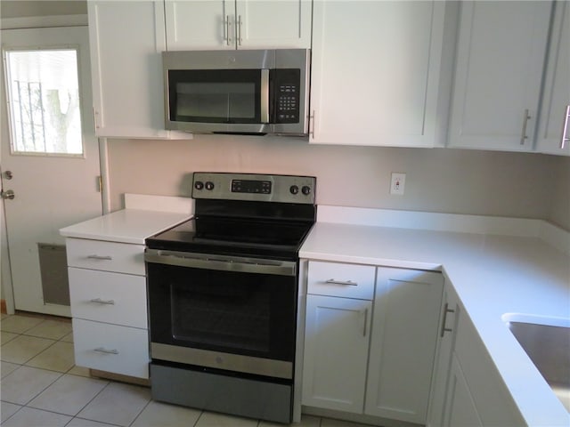 kitchen with white cabinets, sink, stainless steel appliances, and light tile patterned floors