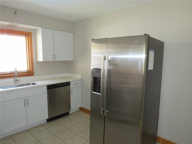 kitchen with light tile patterned flooring, white cabinets, appliances with stainless steel finishes, and sink