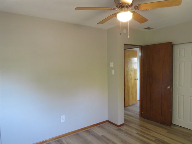 empty room with ceiling fan and light hardwood / wood-style floors