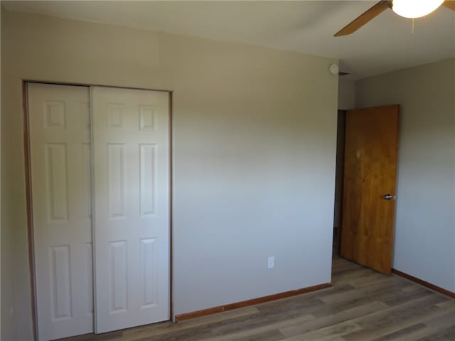 unfurnished bedroom featuring ceiling fan, a closet, and light hardwood / wood-style floors