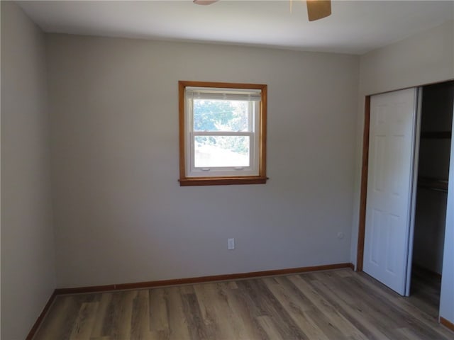 unfurnished bedroom featuring ceiling fan, a closet, and dark hardwood / wood-style flooring