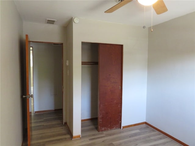 unfurnished bedroom featuring a closet, hardwood / wood-style floors, and ceiling fan