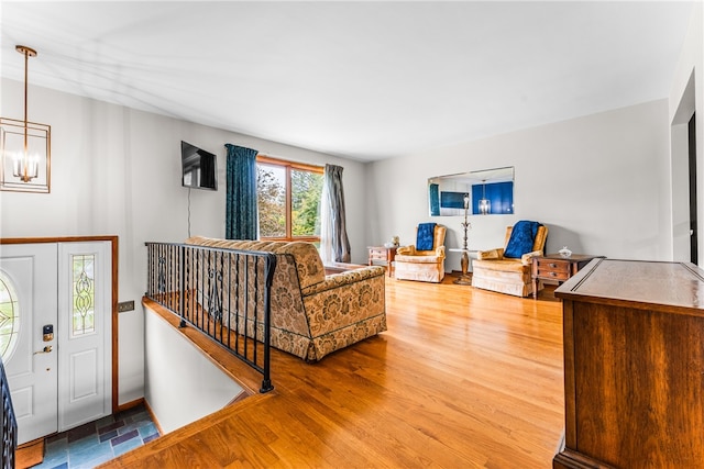 living room featuring wood-type flooring and a notable chandelier