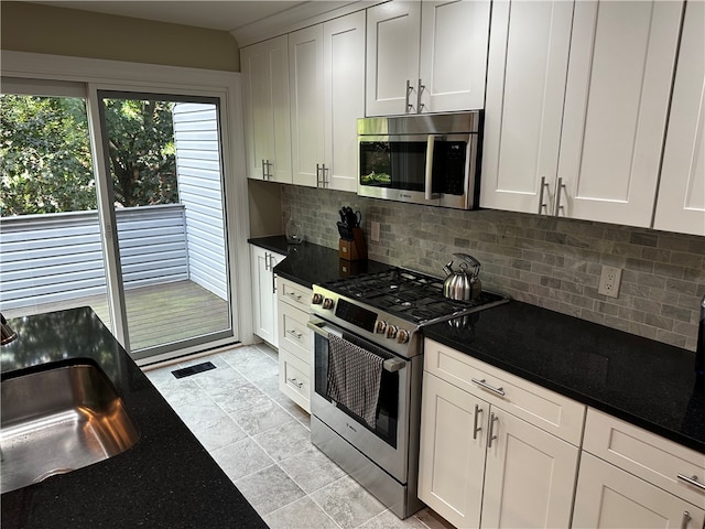 kitchen with white cabinets, appliances with stainless steel finishes, sink, and decorative backsplash