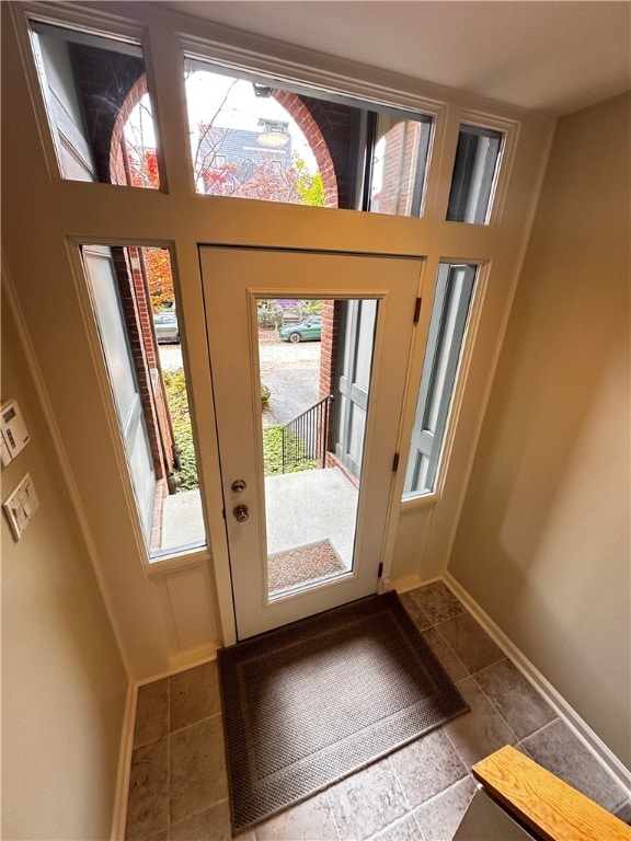 doorway with a healthy amount of sunlight and tile patterned flooring