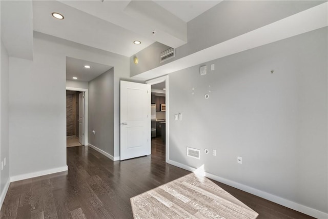 empty room with recessed lighting, visible vents, baseboards, and wood finished floors