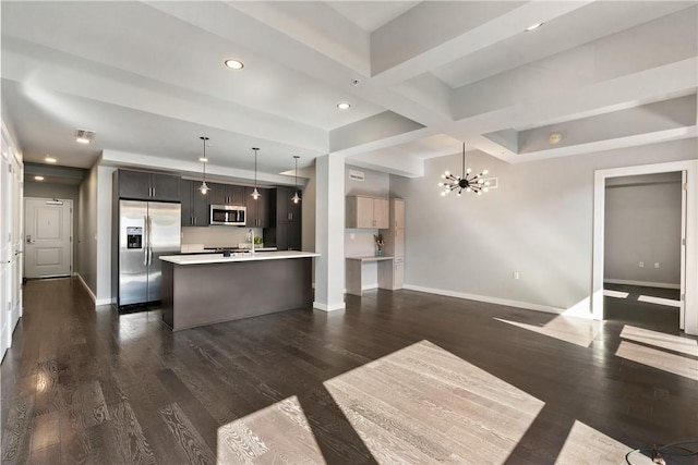 kitchen featuring appliances with stainless steel finishes, open floor plan, light countertops, and baseboards