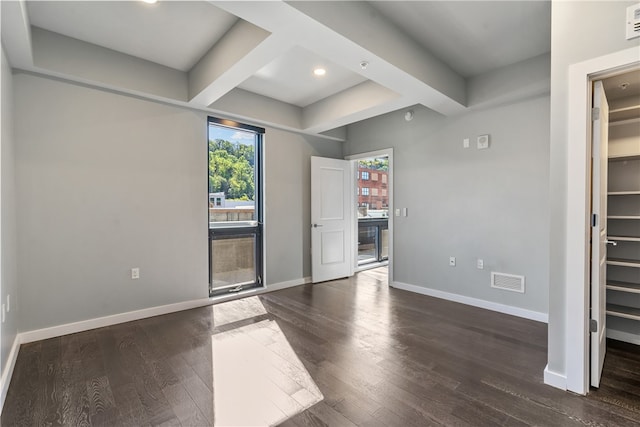 unfurnished room featuring dark hardwood / wood-style floors and beam ceiling