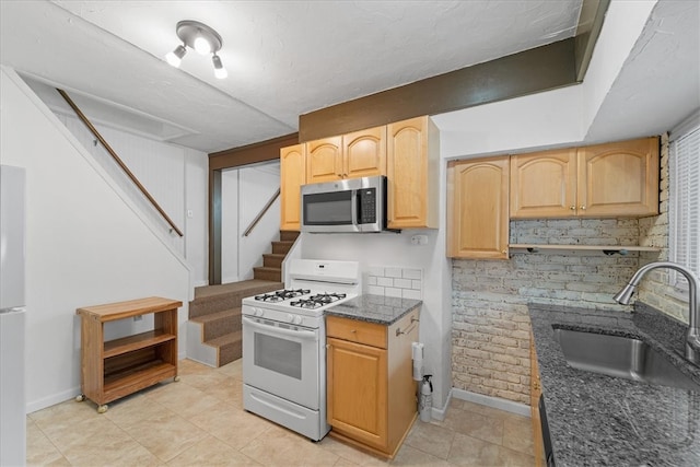 kitchen with light tile patterned floors, sink, white appliances, backsplash, and light brown cabinetry