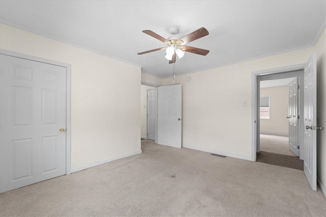 unfurnished bedroom with crown molding, ceiling fan, and light colored carpet