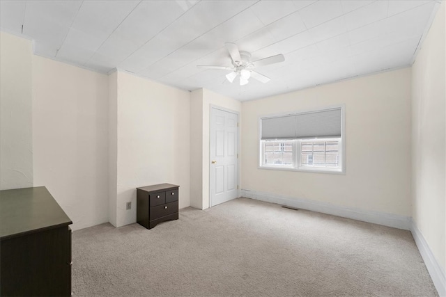 empty room with ceiling fan and light carpet