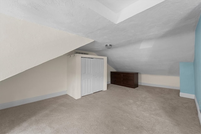 bonus room featuring light carpet, a textured ceiling, and vaulted ceiling