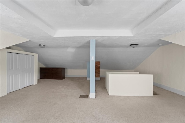 bonus room with light carpet, vaulted ceiling, and a textured ceiling