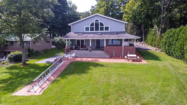 rear view of property featuring a yard and a patio area