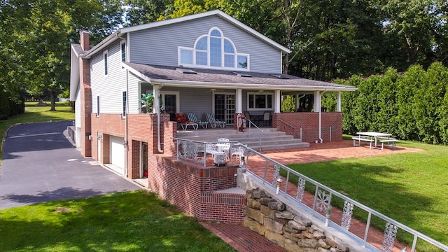 rear view of house with a garage and a lawn