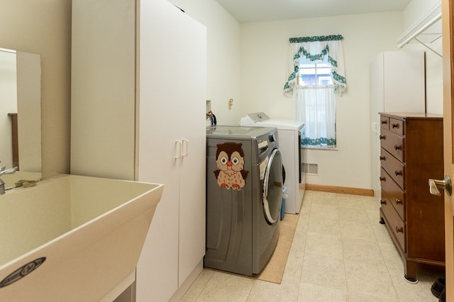 washroom with washing machine and clothes dryer, sink, and light tile patterned floors