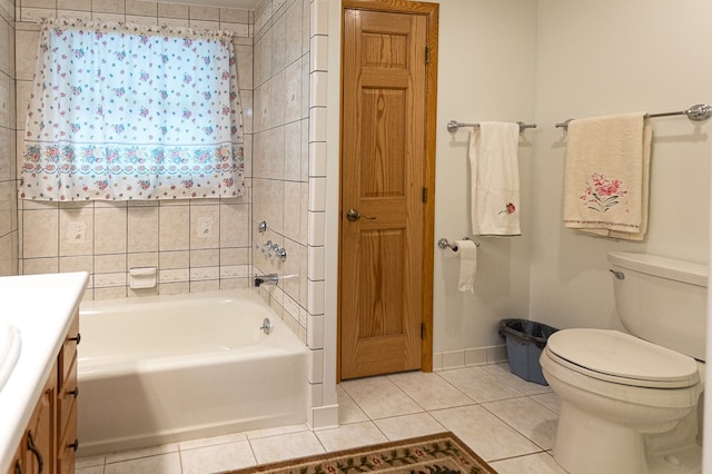 bathroom with tile patterned floors, a tub, vanity, and toilet