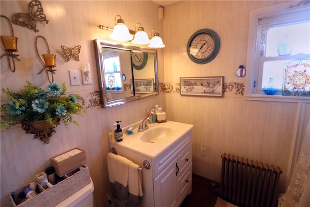 bathroom with vanity, toilet, and radiator heating unit