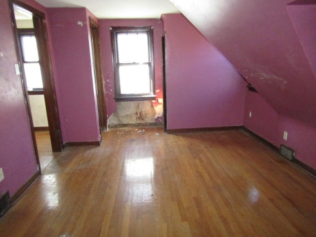 additional living space with dark hardwood / wood-style floors and vaulted ceiling