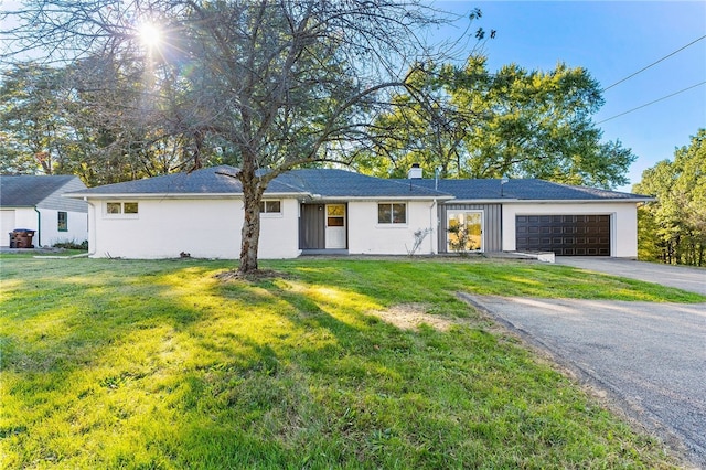 single story home featuring a front yard and a garage