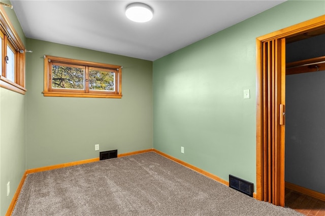 unfurnished bedroom with multiple windows, a closet, and carpet