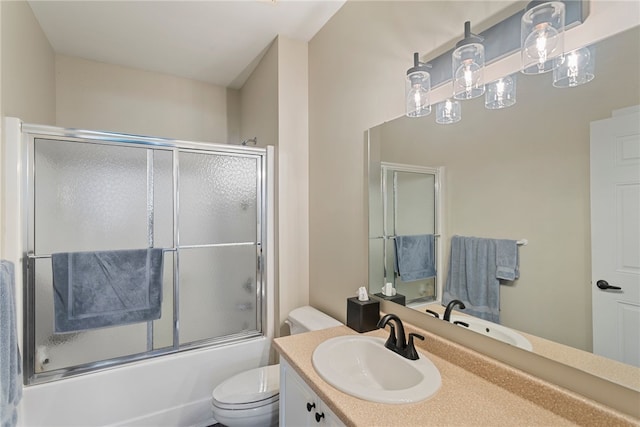 full bathroom with bath / shower combo with glass door, vanity, and toilet