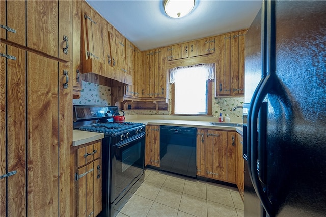 kitchen featuring light tile patterned flooring, black appliances, and sink