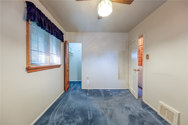 unfurnished room featuring dark colored carpet and ceiling fan