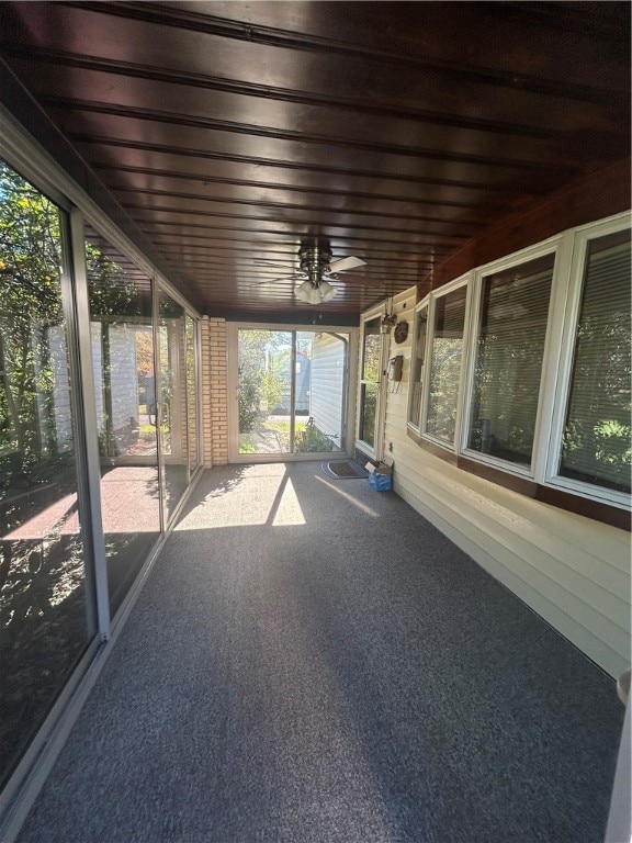 unfurnished sunroom with ceiling fan