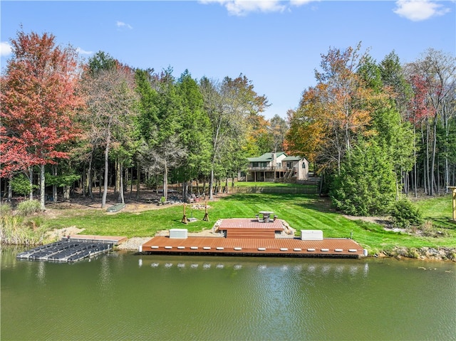 view of dock featuring a lawn and a water view