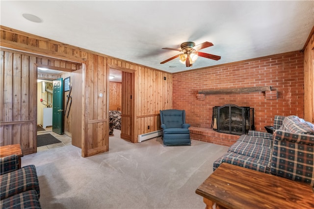 living room with light carpet, a fireplace, wood walls, and baseboard heating