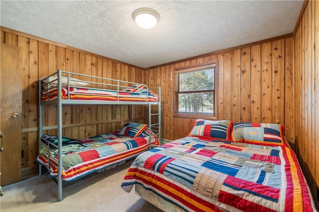 carpeted bedroom featuring ornamental molding, wood walls, and a textured ceiling