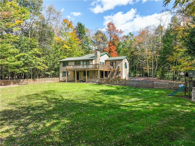 back of house with a playground, a deck, and a lawn