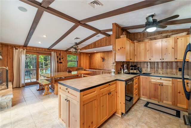 kitchen with ceiling fan, vaulted ceiling with beams, wood walls, and light tile patterned floors