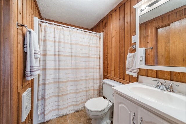 bathroom with vanity, wood walls, tile patterned flooring, a textured ceiling, and toilet