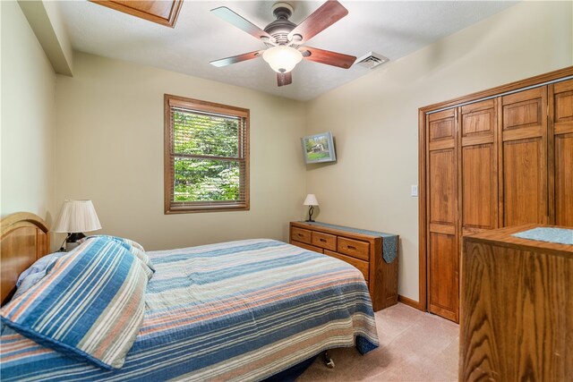 carpeted bedroom with ceiling fan and a closet