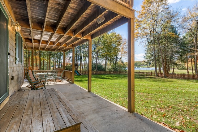 wooden deck with a water view and a yard